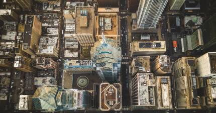 Aerial view of city skyscrapers and streets forming a grid pattern in an urban downtown area.
